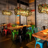 Industrielle Pendelleuchte mit Eisenrahmen und floralen Akzenten